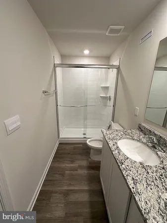 a bathroom with a granite countertop sink a mirror and shower