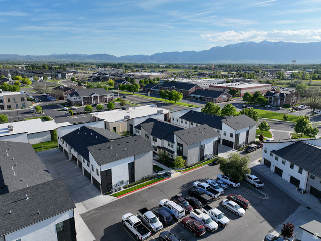 220 Spring Creek Parkway Providence, UT 84332 - Photo 12 of 17 Modern residential development with a mountain backdrop, featuring multi-story units with dark pitched roofs and contrasting light and dark exterior panels