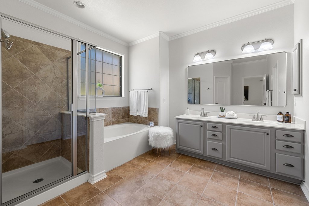 11129 Bastogne Loop Austin, TX 78739 - Photo 20 of 40 Dual vanities, a soaking tub, a large walk-in shower, and an updated mirror create a setup that feels both practical and relaxing.