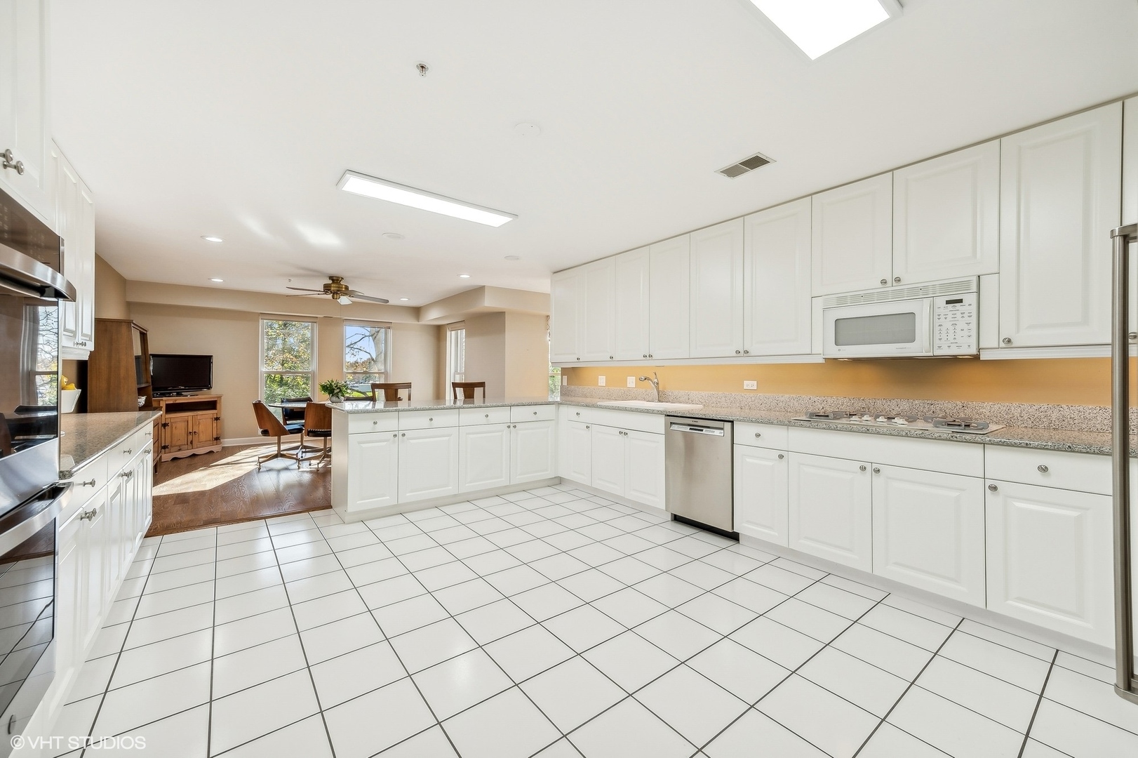 360 Green Bay Road, Unit 3D Winnetka, IL 60093 - Photo 13 of 30 a large white kitchen with a stove a sink dishwasher and white cabinets with wooden floor