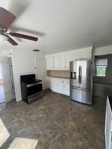 a kitchen with granite countertop a refrigerator and a stove top oven