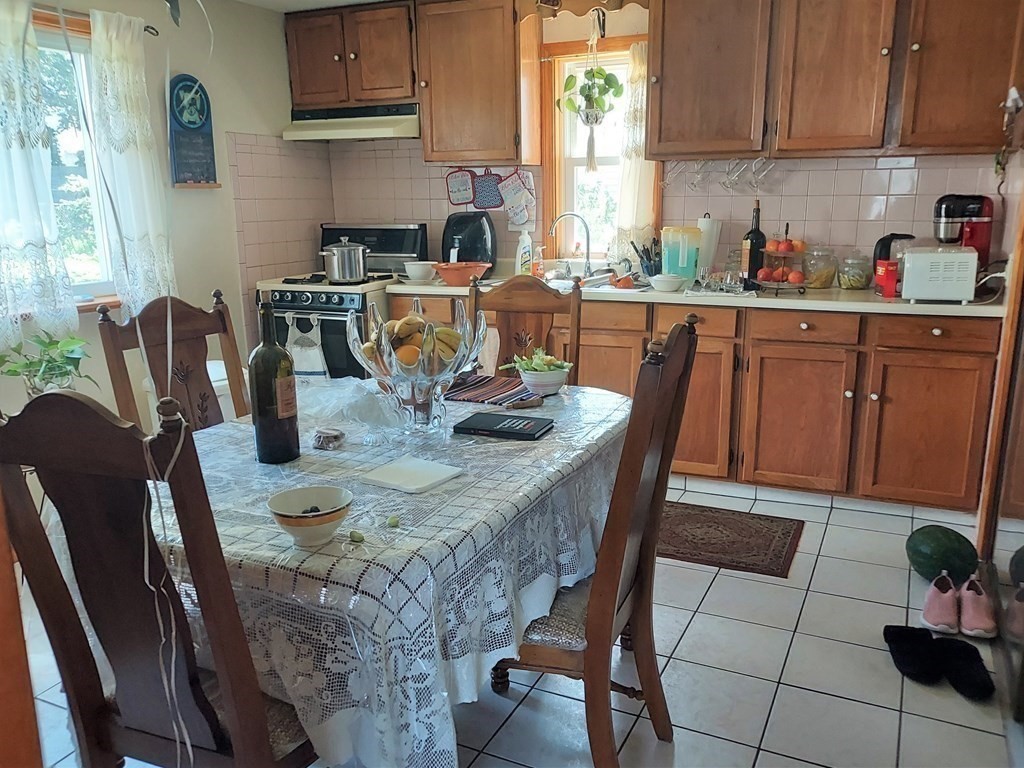 30 Carver Street Fall River, MA 02721 - Photo 5 of 19 a kitchen with stainless steel appliances kitchen island granite countertop a table chairs and a wooden cabinets