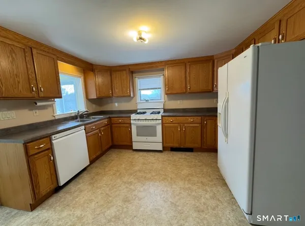 a kitchen with a refrigerator sink and cabinets