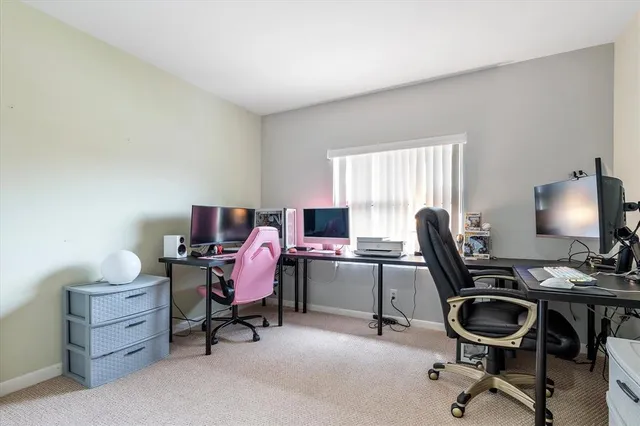 a view of a workspace with furniture and a window