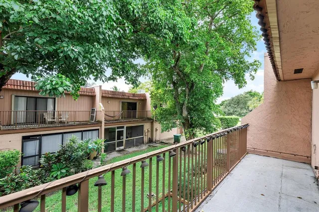 a balcony with wooden fence and trees