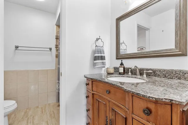a bathroom with a granite countertop sink and a mirror