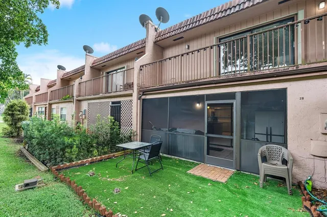a backyard of a house with table and chairs