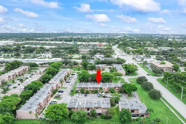 an aerial view of residential houses with outdoor space and trees