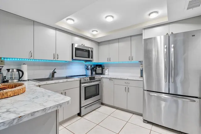 a kitchen with stainless steel appliances granite countertop a refrigerator stove microwave and sink