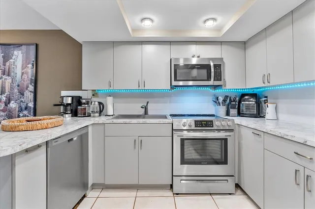a kitchen with cabinets stainless steel appliances and a sink