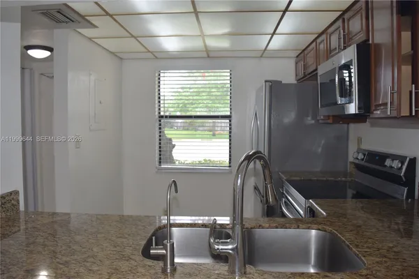 a view of an empty room with a kitchen
