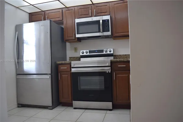 a kitchen with granite countertop cabinets stainless steel appliances and wooden cabinets