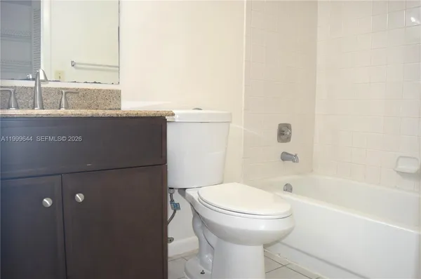 a bathroom with a granite countertop sink and a toilet