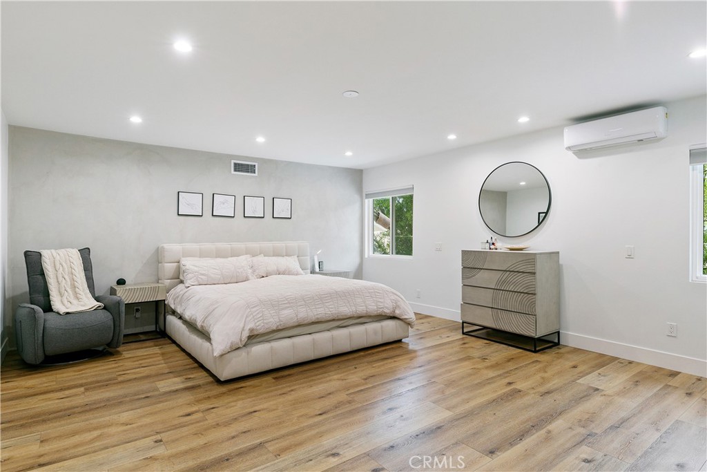 24411 Highlander Road West Hills, CA 91307 - Photo 32 of 58 a spacious bedroom with a bed a mirror and lamp on desk