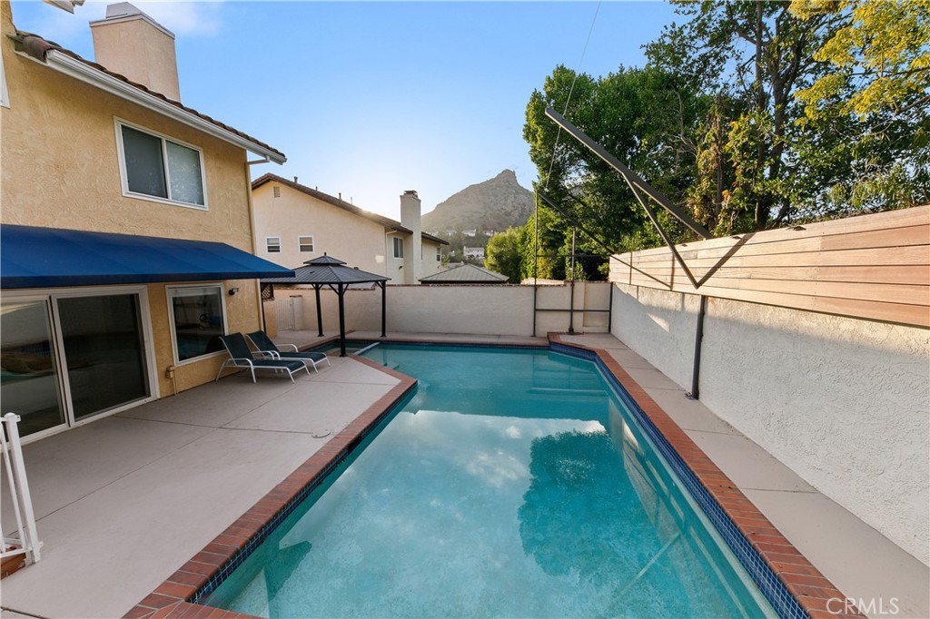 24411 Highlander Road West Hills, CA 91307 - Photo 47 of 58 a view of a house with a backyard and a patio