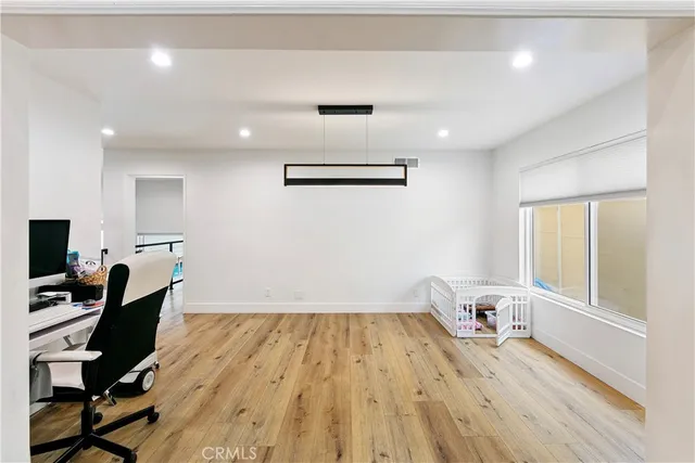 a view of a workspace with furniture and wooden floor