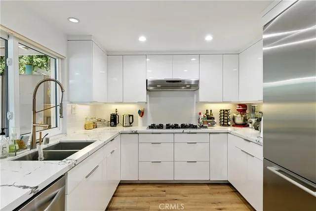 a kitchen with a sink white cabinets and white appliances
