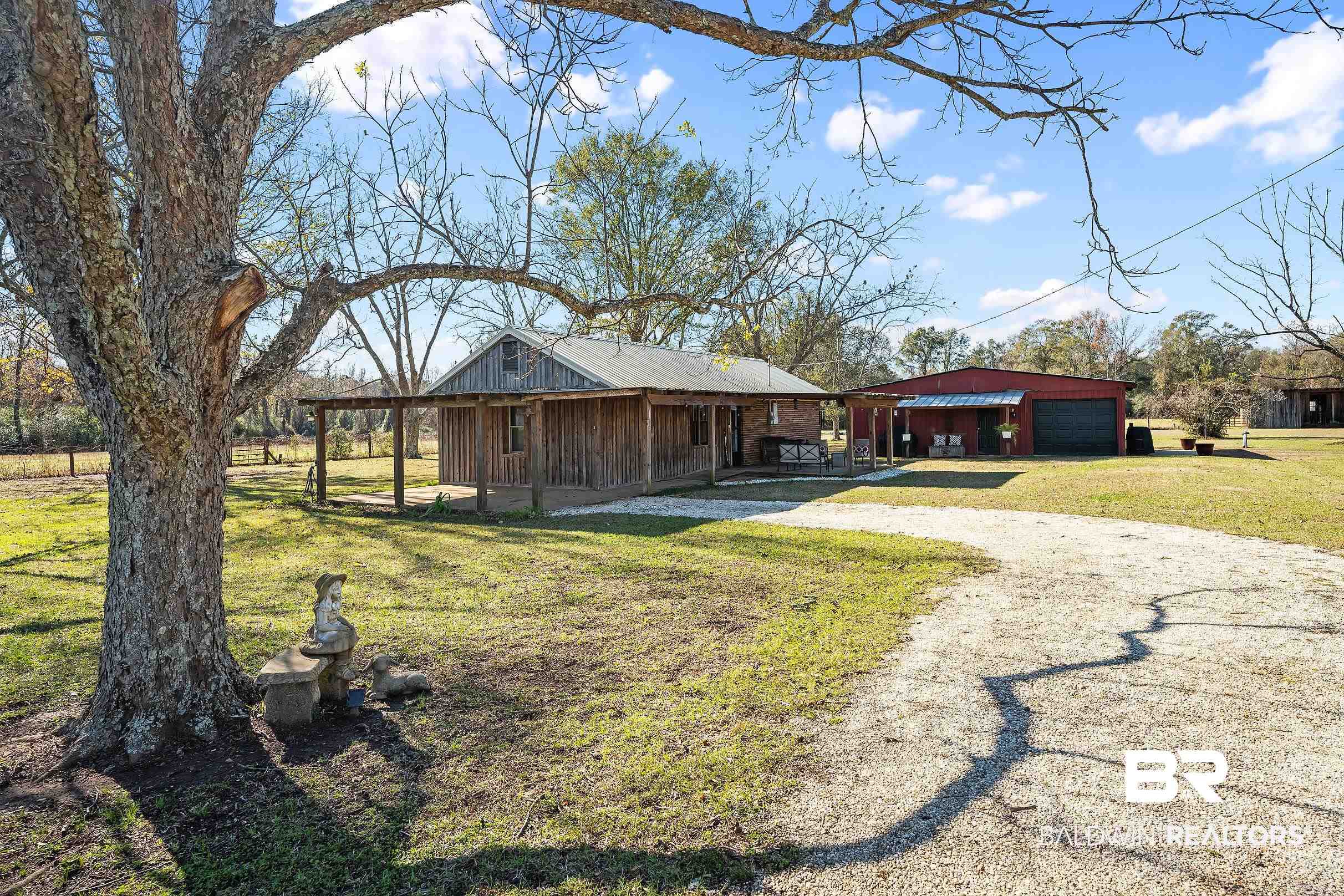 110 Sam Jones Road Atmore, AL 36502 - Photo 2 of 47 View of front of property with a front yard, dirt driveway, an outdoor structure, covered porch, and a garage