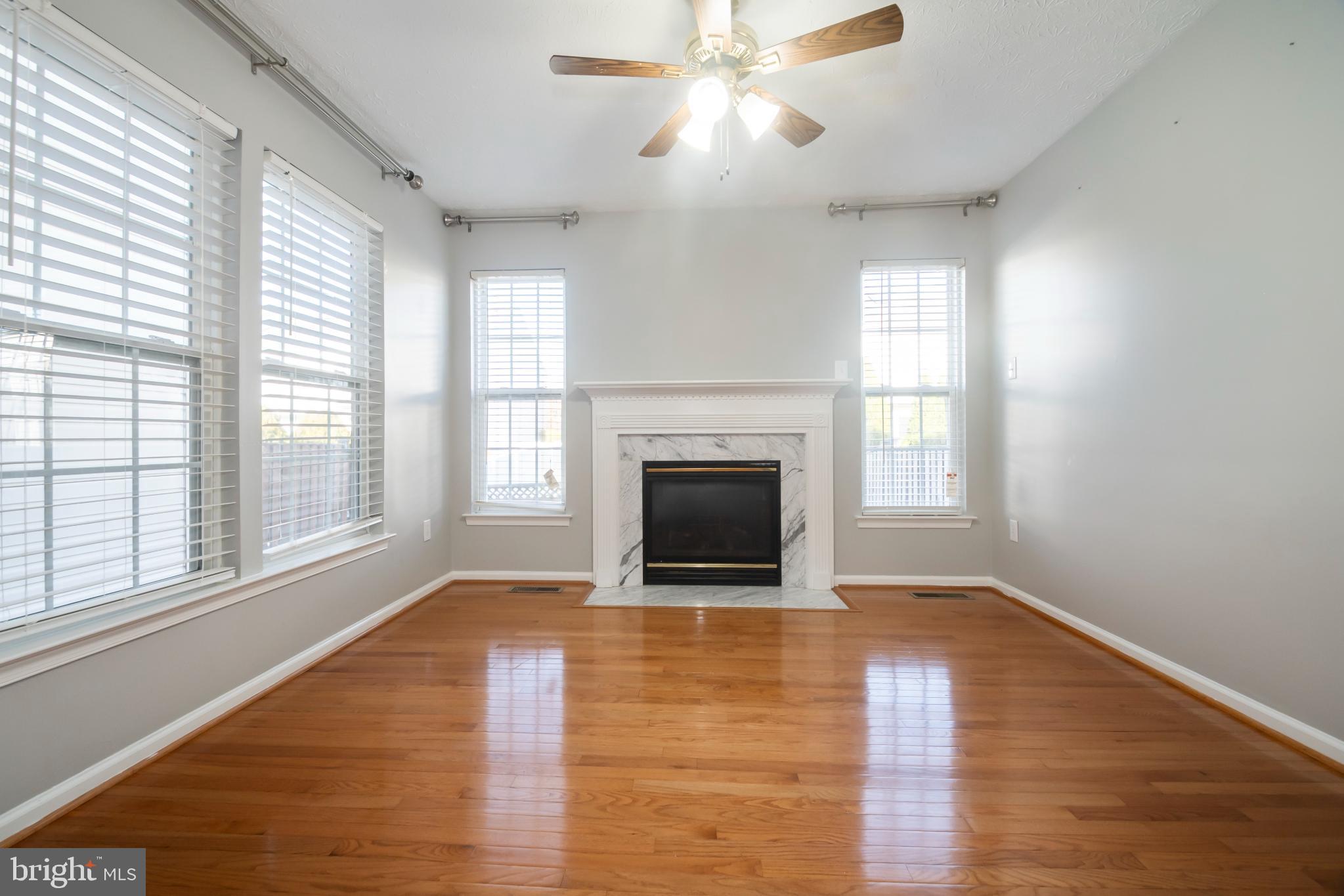 5224 Leavers Court Rosedale, MD 21237 - Photo 5 of 27 wooden floor fireplace and windows in an empty room