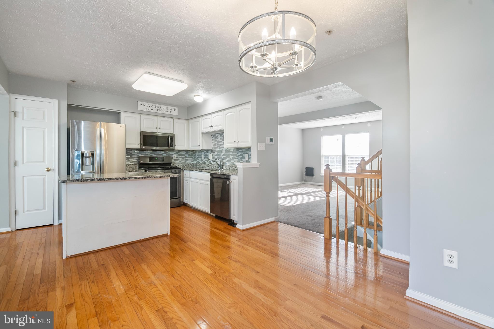 5224 Leavers Court Rosedale, MD 21237 - Photo 10 of 27 a kitchen with stainless steel appliances granite countertop a refrigerator a stove oven and white countertops with wooden floor