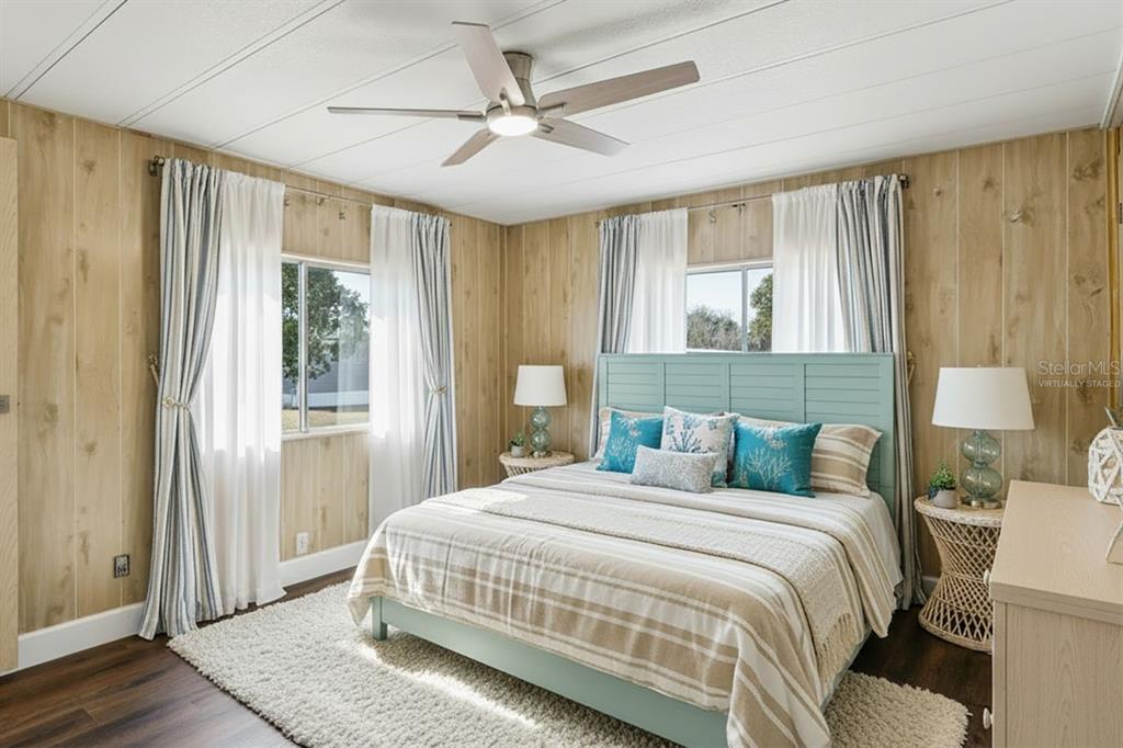 15071 Rialto Avenue Brooksville, FL 34613 - Photo 15 of 41 a bedroom with a large bed and a chandelier