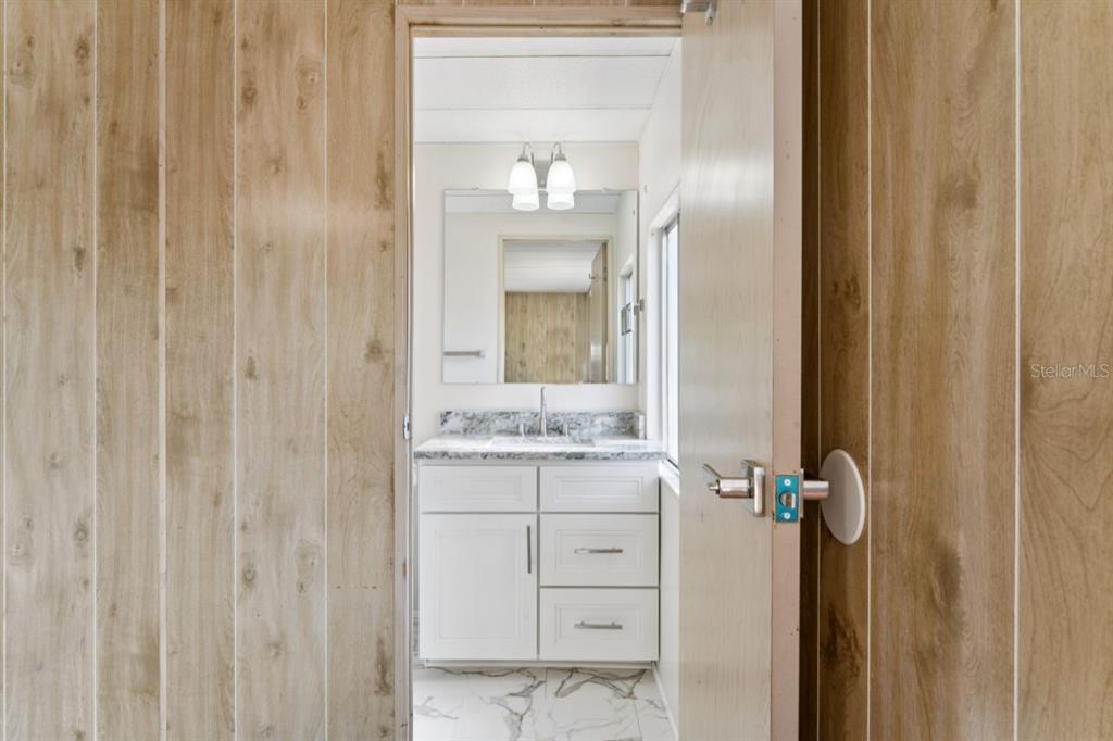 15071 Rialto Avenue Brooksville, FL 34613 - Photo 17 of 41 a bathroom with a granite countertop sink a mirror and a