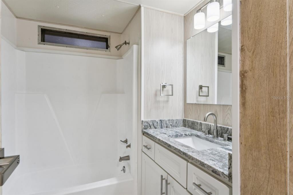 15071 Rialto Avenue Brooksville, FL 34613 - Photo 22 of 41 a bathroom with a granite countertop sink and a mirror