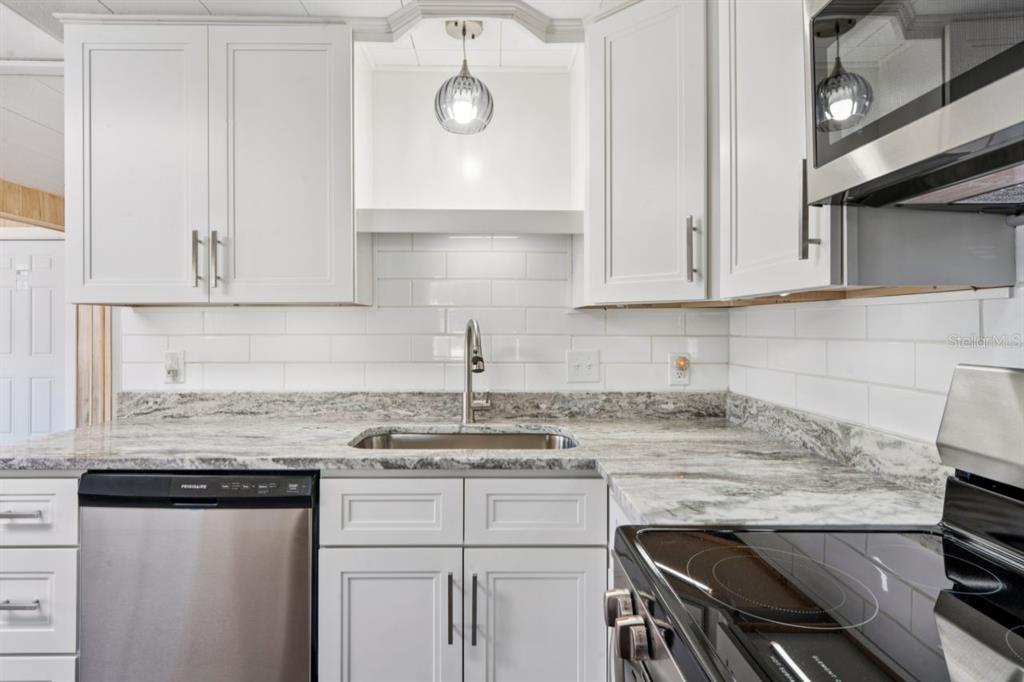 15071 Rialto Avenue Brooksville, FL 34613 - Photo 5 of 41 a kitchen with granite countertop white cabinets and white appliances