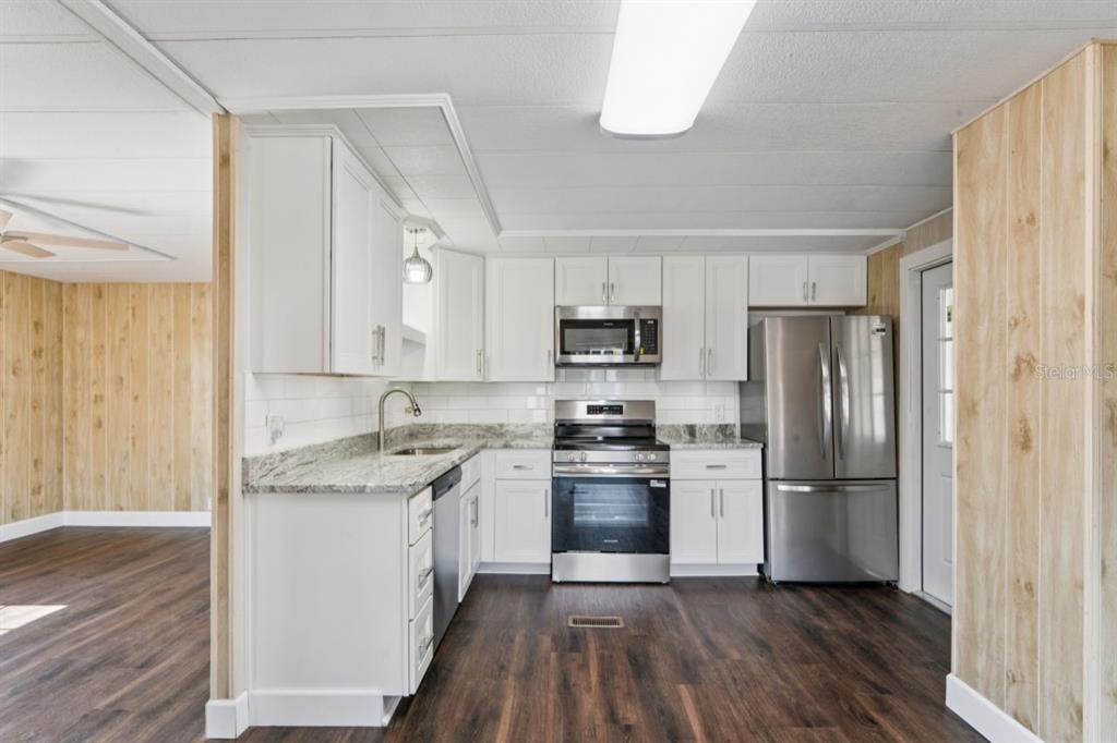 15071 Rialto Avenue Brooksville, FL 34613 - Photo 7 of 41 a kitchen with white cabinets and stainless steel appliances