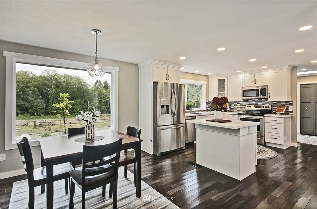 971 Sandy Point Road Langley, WA 98260 - Photo 6 of 25 a kitchen with refrigerator cabinets dining table and chairs