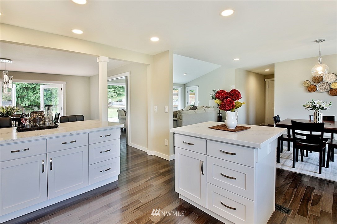 971 Sandy Point Road Langley, WA 98260 - Photo 7 of 25 a kitchen with white cabinets and wooden floor