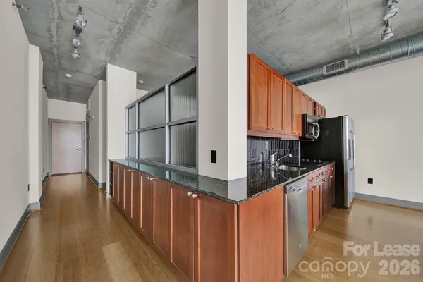 a view of a room with wooden floor and white walls