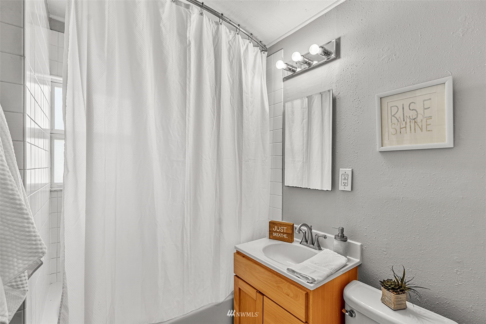 1818 Maple Street Everett, WA 98201 - Photo 9 of 37 a bathroom with a sink a toilet and a mirror