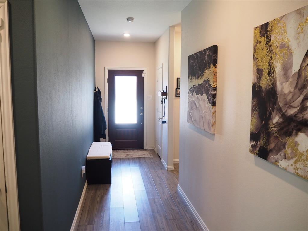 1116 Mesquite Lane Princeton, TX 75407 - Photo 19 of 28 a view of a hallway with wooden floor and staircase