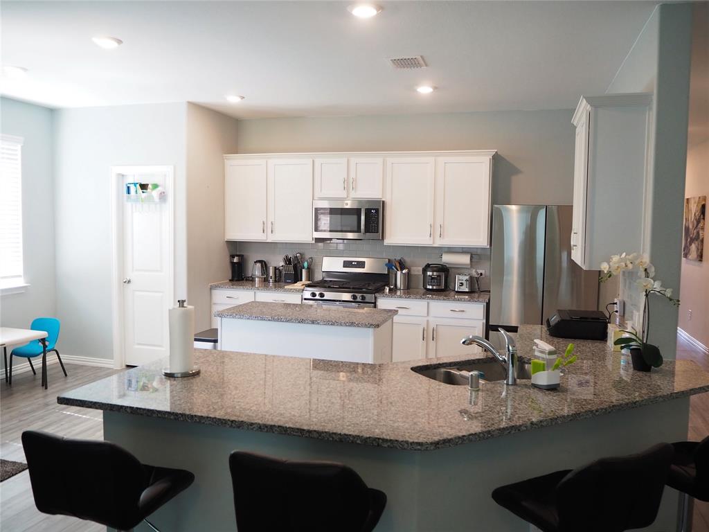 1116 Mesquite Lane Princeton, TX 75407 - Photo 4 of 28 a kitchen with granite countertop a sink refrigerator and cabinets