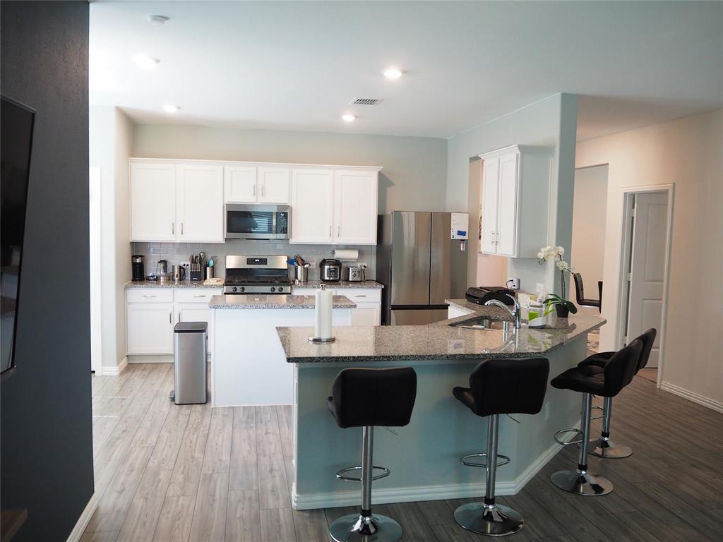 1116 Mesquite Lane Princeton, TX 75407 - Photo 6 of 28 a kitchen with stainless steel appliances kitchen island granite countertop a stove top oven a sink a dining table and chairs