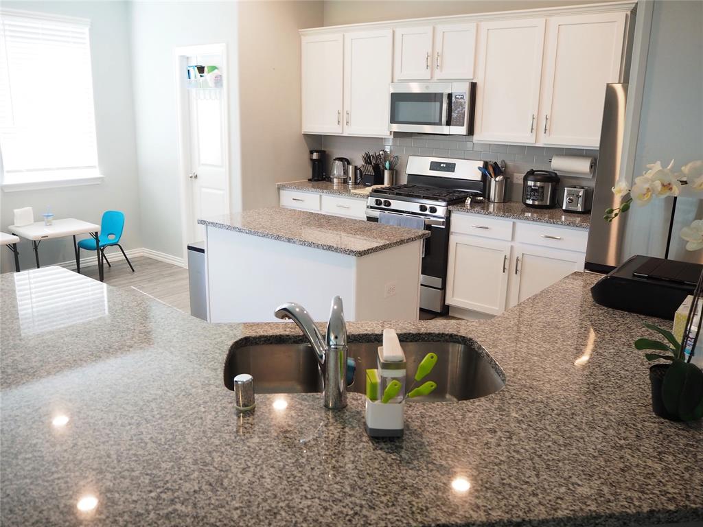 1116 Mesquite Lane Princeton, TX 75407 - Photo 7 of 28 a kitchen with a sink appliances and cabinets