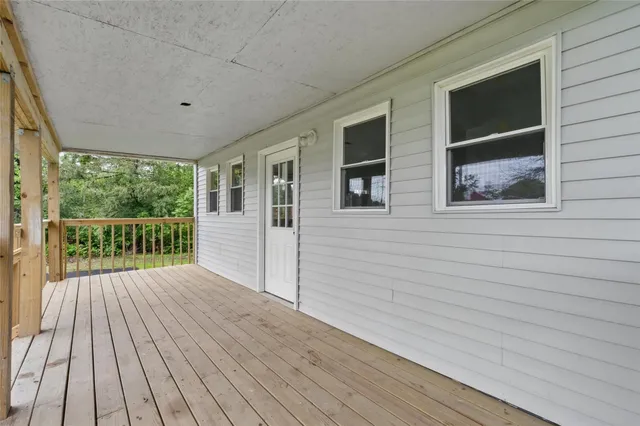a view of backyard with wooden floor and fence