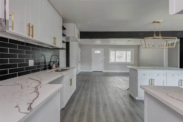a kitchen with kitchen island granite countertop a sink and refrigerator