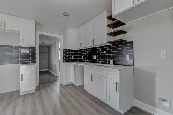a kitchen with white cabinets and a stove
