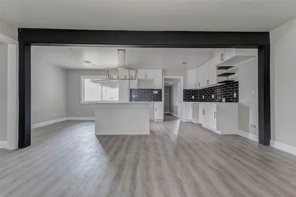 a view of a kitchen with wooden floor and electronic appliances