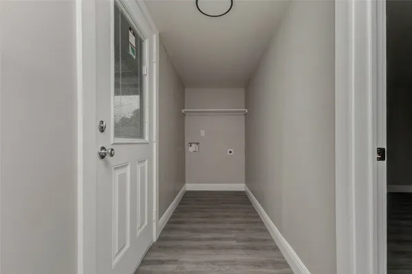 a view of a hallway with wooden floor and glass door
