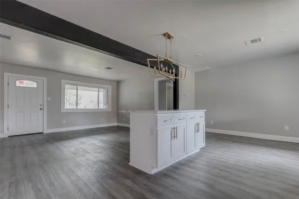 a hallway with white cabinets and wooden floor