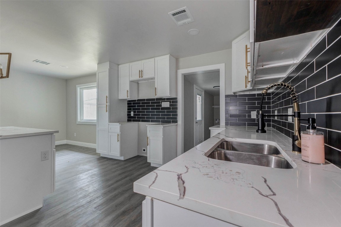 511 Wagers Street Conroe, TX 77301 - Photo 30 of 39 a kitchen that has a sink and a stove with wooden floor