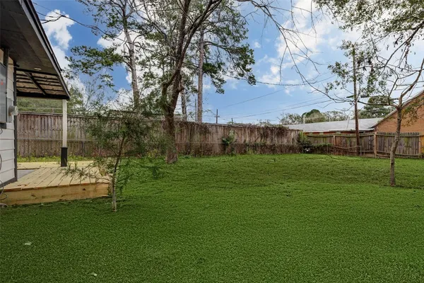 a view of a house with backyard and a tree