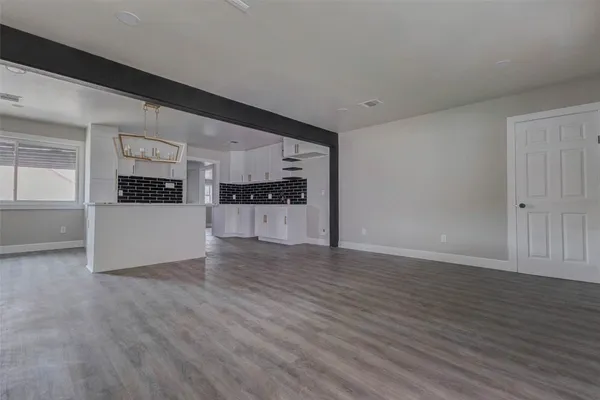 a view of a kitchen with wooden floor and electronic appliances