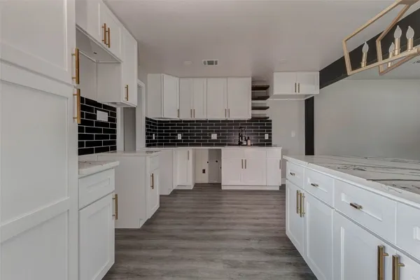 a kitchen with cabinets and wooden floor