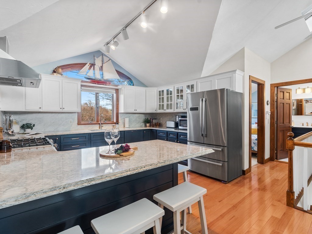 8 Moorland Road, Unit 3 Gloucester, MA 01930 - Photo 1 of 38 a kitchen with granite countertop a refrigerator a stove a sink dishwasher and white cabinets with wooden floor