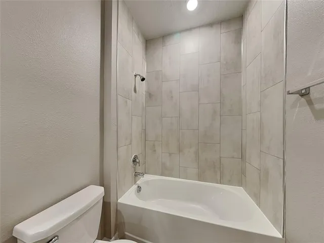 a white bath tub sitting next to a toilet