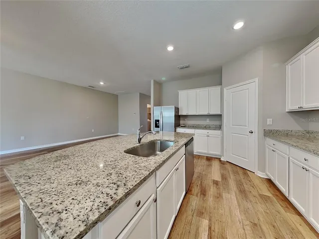 a kitchen with white cabinets a sink and dishwasher